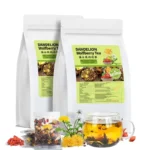 Product photo showing two white resealable pouches of Dandelion Wolfberry Tea (蒲公英枸杞茶), Net Content: 144 grams (12 grams x 12 packs). The foreground features a clear mug of brewed tea, loose Goji berries, a dandelion flower, and a clear individual tea packet showing the dried herbal mix of dandelion, goji berries, and chrysanthemum flowers.